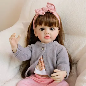 Bambola reborn da 22 pollici con cardigan grigio e fascia per capelli rosa