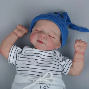 Bambola reborn realistica da 18 pollici con abito a righe e cappello blu su fondo grigio
