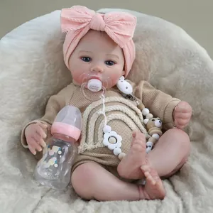 18-inch Meadow reborn baby doll with khaki knit romper and pink bow headband