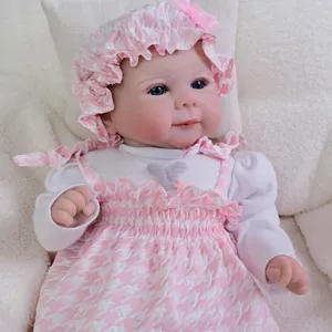Lifelike 19-inch Reborn Baby Doll in pink floral dress and matching bonnet on plush rug
