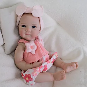 Realistic 18-inch reborn baby doll in pink floral outfit with a large bow headband