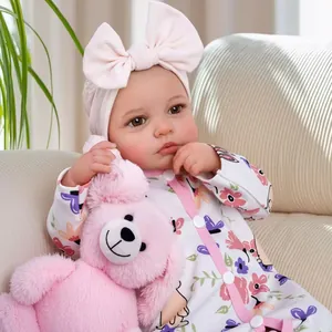 18-inch awake reborn baby doll in floral romper with pink headband and plush bear