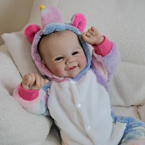 Realistic 19 inch reborn baby doll Vivienne in colorful unicorn plush romper on soft background