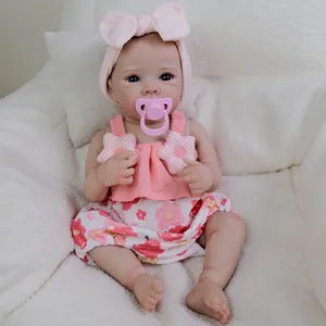 Realistic 18-inch newborn baby doll in pink floral dress with blue eyes and pacifier