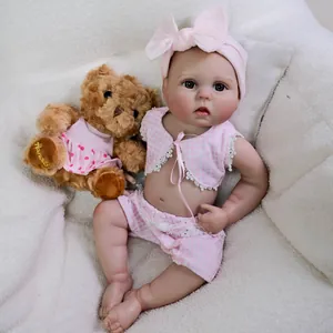 Realistic 22-inch reborn baby doll in pink plaid outfit with a matching headband