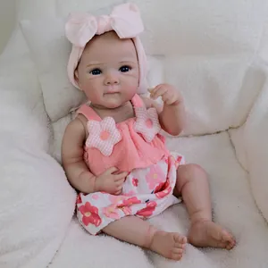 Lifelike 18 inch reborn baby doll with blue eyes in a pink floral outfit and headband