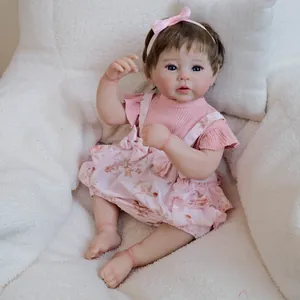 Realistic 19-inch reborn baby doll Raven in pink floral outfit on plush background