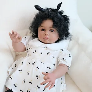 Reborn baby girl doll with dark skin and curly hair in a white cherry print dress