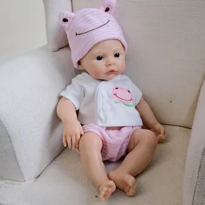 12-inch realistic reborn baby doll in pink frog print outfit on white sofa