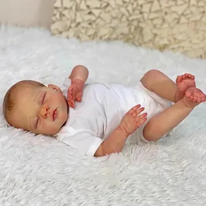 Lifelike 18-inch newborn reborn doll in white bodysuit sleeping on white plush rug
