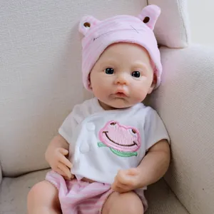 12-inch realistic reborn baby doll in pink frog print outfit on a soft beige sofa