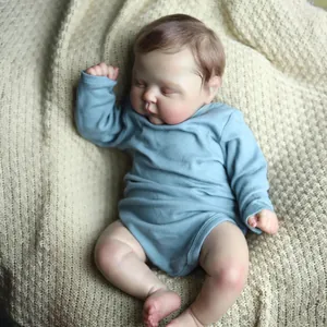 Lifelike 19-inch sleeping reborn doll in blue long-sleeve outfit on a soft knit blanket