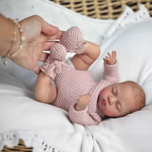 Poupée Reborn réaliste de 10 pouces en barboteuse rose tricotée dormant sur coussin blanc