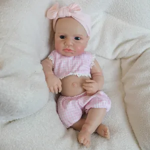 18-inch soft solid silicone reborn doll in pink plaid outfit with bow on white rug
