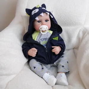 Realistic 19 inch reborn baby doll LouLou wearing a blue dinosaur hoodie and pacifier