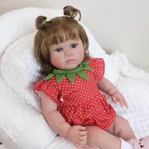 Realistische 21-Zoll Reborn Puppe im roten Erdbeerkleid auf weißem flauschigem Kissen