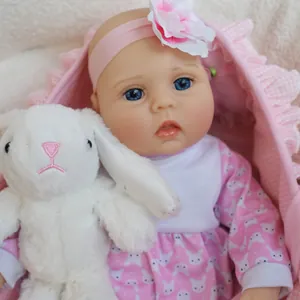 Gros plan d'une poupée réaliste de 16 pouces avec bandeau rose et peluche lapin doux