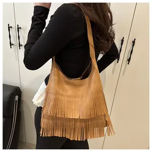 Détail du sac hobo en cuir marron vintage avec des franges bohèmes à plusieurs niveaux