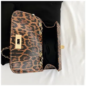 Detail of leopard print shoulder bag showing golden clasp and black fabric lining interior