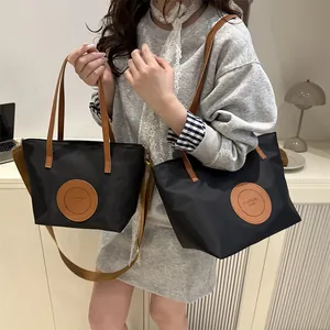 Black nylon tote bag set with brown leather straps and adjustable shoulder strap