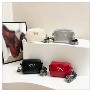 Detail showing colorful crossbody bags with gold bow accents and patterned straps