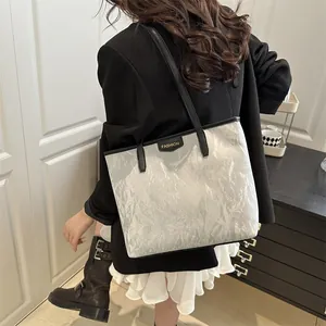 Metallic silver pleated tote bag with large capacity and black handles for daily commuting