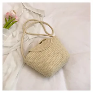 Detail of woven straw shoulder bag with natural beige flap and braided cotton rope strap