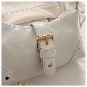 Dettaglio della borsa Hobo bianca con fibbia dorata e rivetti metallici sui lati