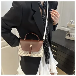 Brown leather flap crossbody bag with cross-pattern print on a stylish female model