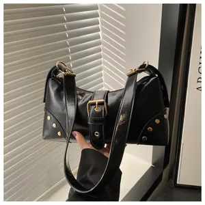 Dettaglio della borsa hobo in pelle nera lucida con fibbia dorata e borchie metalliche