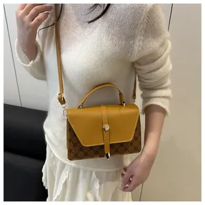 Detail showing vintage yellow and brown patchwork crossbody bag with diamond pattern