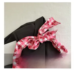 Close-up of pink and white checkered floral ribbon bow tied on a handbag handle