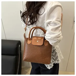 Detailed woven texture and golden round buckle on caramel brown PU leather bag