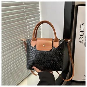 Detail of woven texture black PU leather tote with brown handles and gold snap buckle