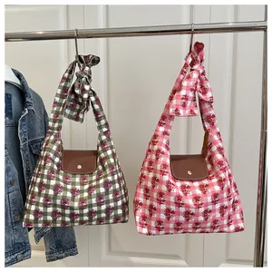 Detail of plaid tote bags with floral prints, leather flaps and decorative bows