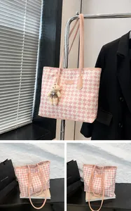 Detail of pink plaid tote bag with Jingpin label and cute bear charm attachment