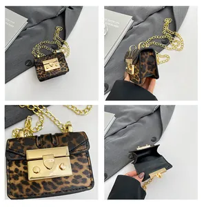 Macro detail of leopard print mini bag featuring glossy gold clasp and chain strap