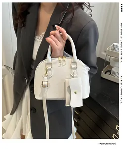 White shell-shaped handbag with leather texture and small accessory pouch details