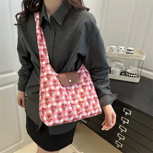 Pink floral checkered tote bag with brown leather flap and wide shoulder strap