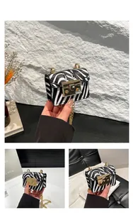 Detail of zebra pattern mini crossbody bag with gold chain and rectangle lock