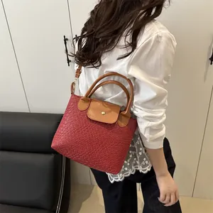 Fashionable woven texture red handbag with brown handles and adjustable strap