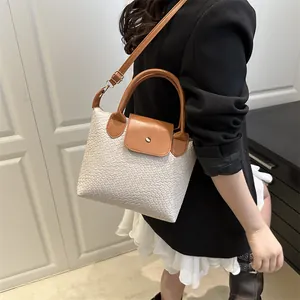 Fashionable beige woven handbag with brown leather straps and metal magnetic clasp closure