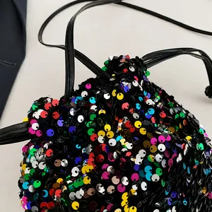 Detail of colorful sequins and black drawstring closure on a bucket bag for women