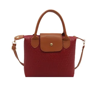 Red woven texture handbag with brown leather handles and golden metal buckle