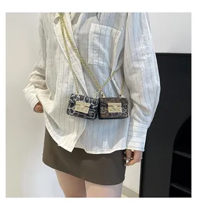 Detail of mini animal print crossbody bags with gold chain straps and metal buckle locks