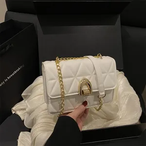 Sac bandoulière matelassé blanc avec fermoir fer à cheval doré et chaîne élégante femme