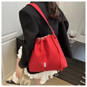 Detail of red canvas drawstring bag with checkered trim and Fashion label on the side