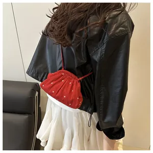Detail van rode crossbodytas met bloemenpatroon en ruches gedragen door een modieus model