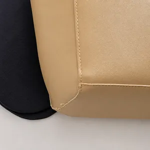 Macro shot of precise stitching on beige pebbled leather handbag with blue fabric detail