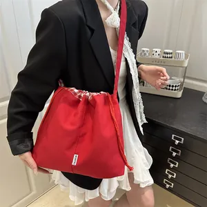 Vibrant red denim crossbody bag with drawstring closure and adjustable strap for women